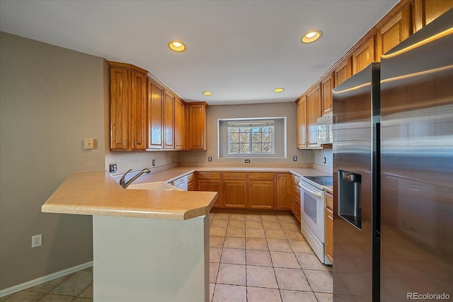 kitchen featuring white appliances, kitchen peninsula, sink, and light tile patterned floors