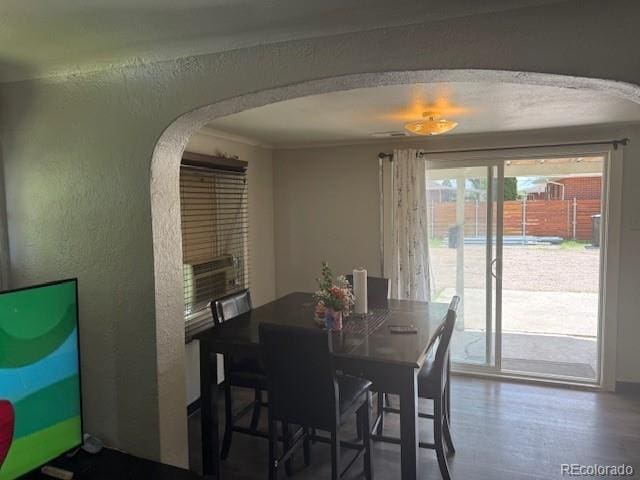 449 Lowell Blvd, Denver, CO 80204 - dining room featuring arched walkways, a textured wall, and wood finished floors