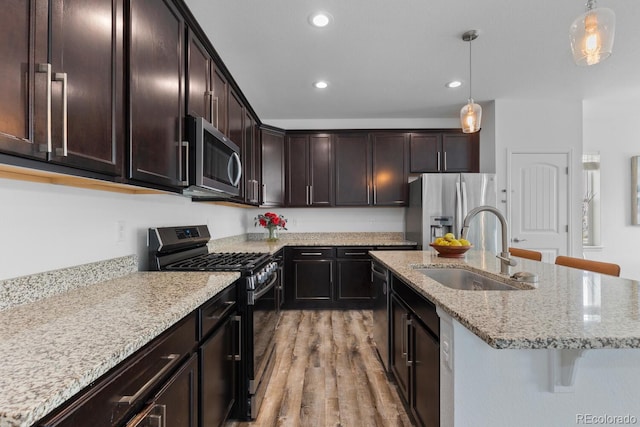 17960 Weymouth Ave, Parker, CO 80134 - kitchen with stainless steel appliances, recessed lighting, light wood-style floors, decorative light fixtures, and light stone counters