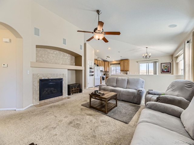 living area featuring arched walkways, plenty of natural light, light colored carpet, and ceiling fan with notable chandelier