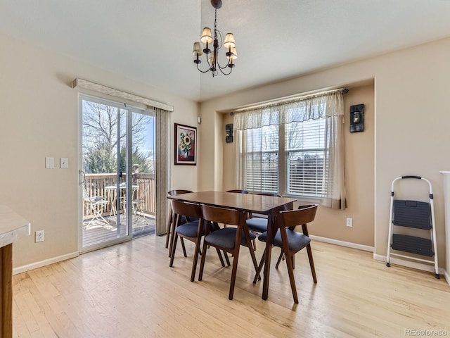 dining area featuring a chandelier, plenty of natural light, light wood-style flooring, and baseboards