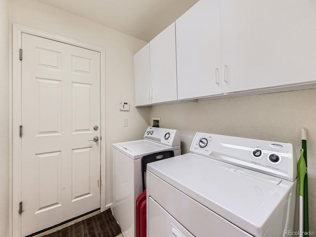 clothes washing area featuring wood finished floors, cabinet space, and independent washer and dryer