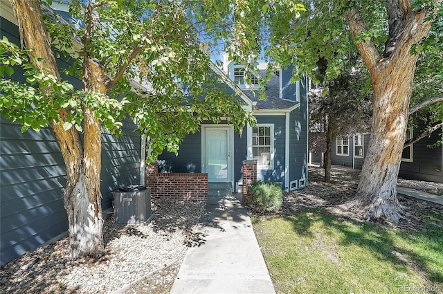 view of front of house featuring a front lawn and cooling unit