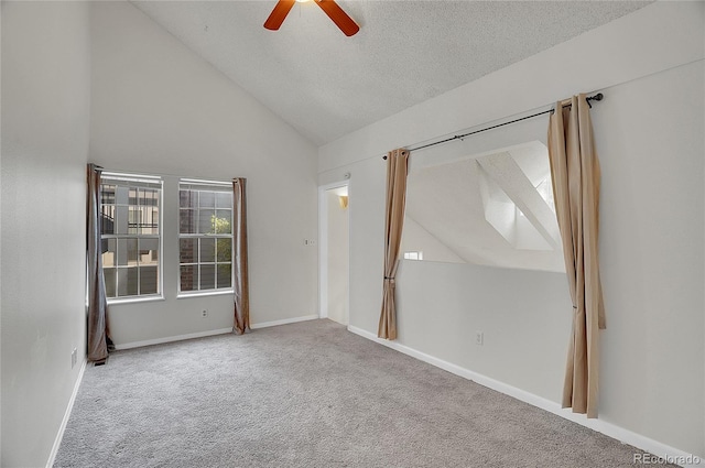 carpeted spare room with a textured ceiling, high vaulted ceiling, and ceiling fan