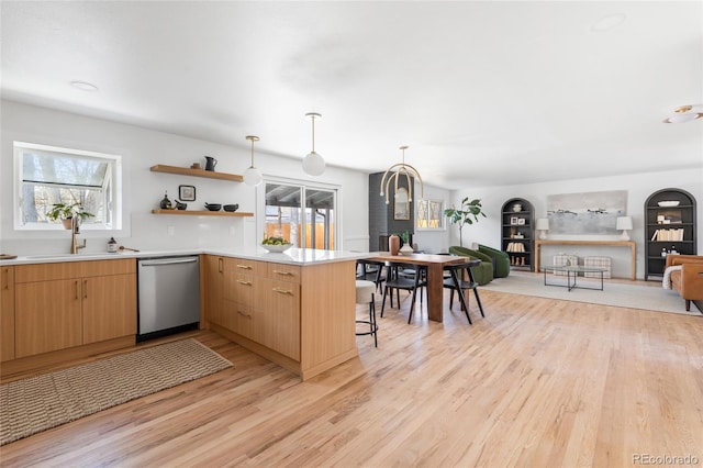 kitchen with kitchen peninsula, a wealth of natural light, stainless steel dishwasher, and hanging light fixtures