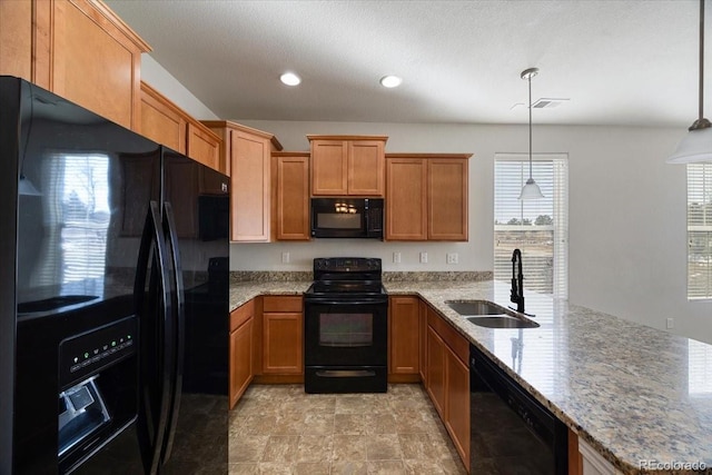 kitchen with sink, light stone counters, decorative light fixtures, kitchen peninsula, and black appliances