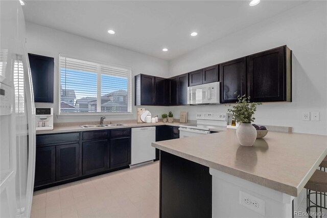 827 Forest Canyon Rd, Severance, CO 80550 - kitchen with white appliances, a sink, a peninsula, light countertops, and recessed lighting
