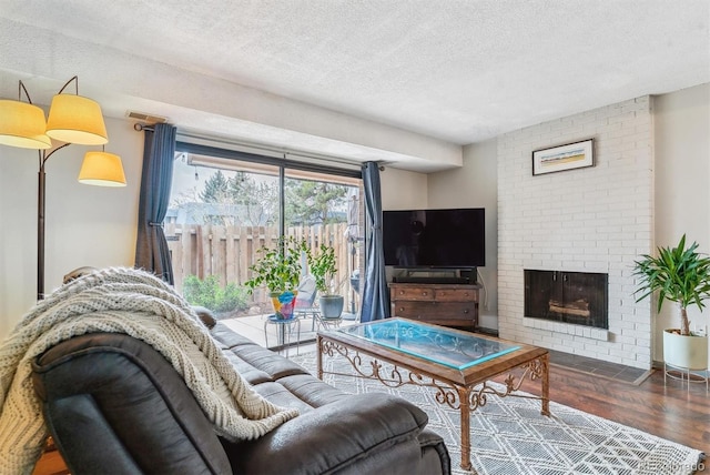 7995 E Mississippi Ave Unit C11, Denver, CO 80247 - living room with a brick fireplace, wood finished floors, and a textured ceiling