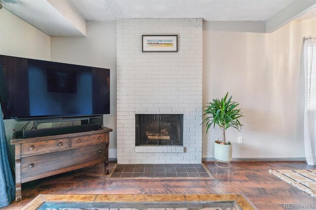 7995 E Mississippi Ave Unit C11, Denver, CO 80247 - living room featuring a brick fireplace, visible vents, a textured ceiling, and wood finished floors
