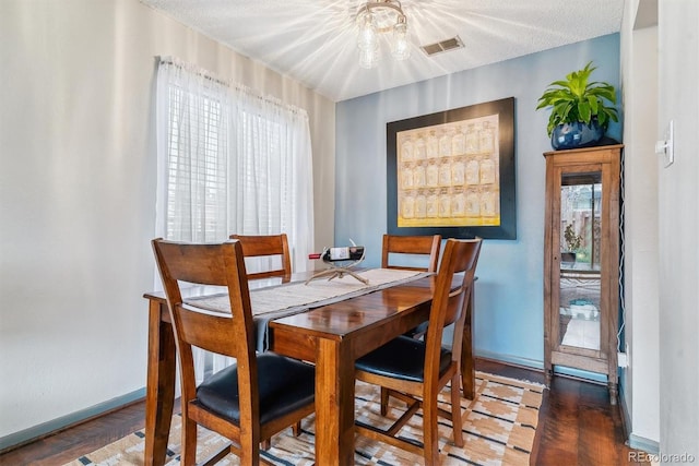 7995 E Mississippi Ave Unit C11, Denver, CO 80247 - dining area featuring a notable chandelier, a textured ceiling, baseboards, and visible vents