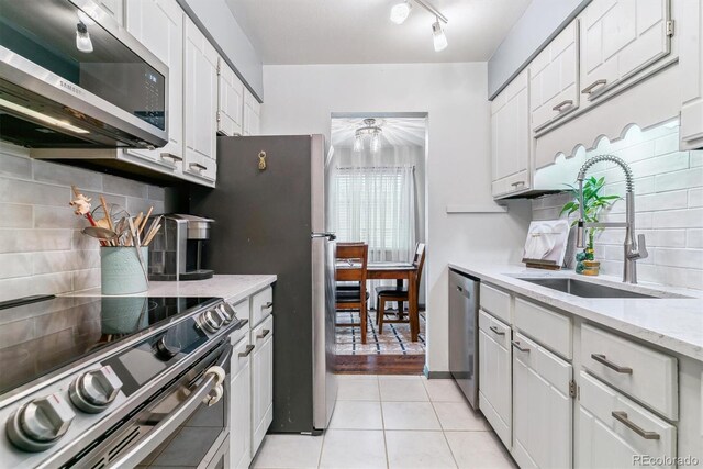 7995 E Mississippi Ave Unit C11, Denver, CO 80247 - kitchen with white cabinetry, a sink, light tile patterned floors, and appliances with stainless steel finishes