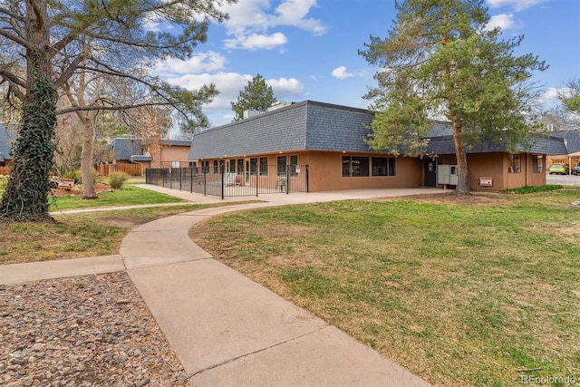7995 E Mississippi Ave Unit C11, Denver, CO 80247 - rear view of property featuring a shingled roof, fence, mansard roof, and a yard