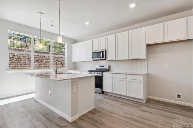 457 Interlocken Blvd Unit 101, Broomfield, CO 80021 - kitchen with stainless steel appliances, decorative backsplash, light wood-type flooring, a sink, and white cabinetry