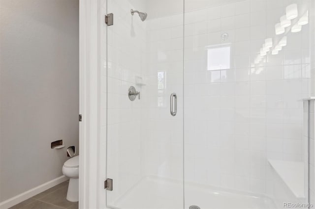 457 Interlocken Blvd Unit 101, Broomfield, CO 80021 - bathroom with a stall shower, toilet, baseboards, and tile patterned floors