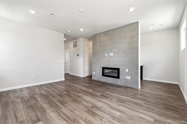 457 Interlocken Blvd Unit 101, Broomfield, CO 80021 - unfurnished living room featuring wood finished floors, a tile fireplace, and recessed lighting
