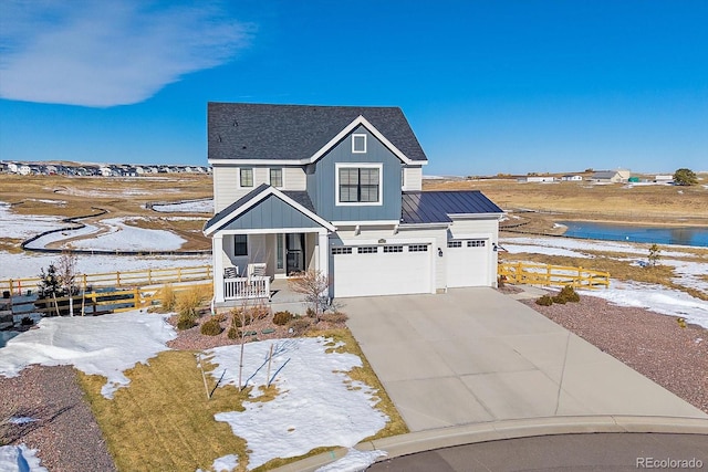 view of front of property featuring a porch, a garage, and a water view