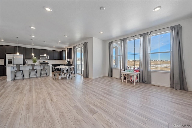 unfurnished living room with a textured ceiling and light hardwood / wood-style floors