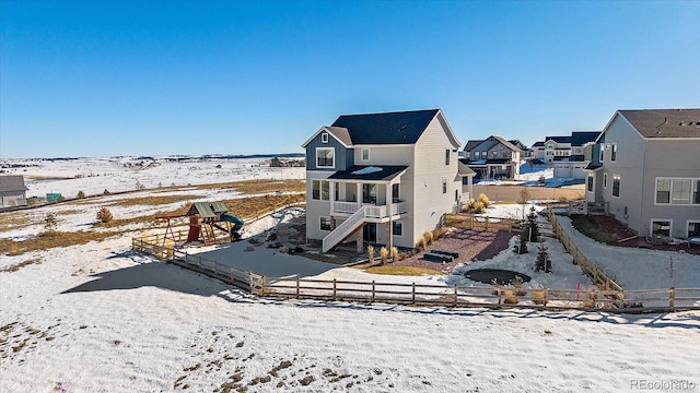 view of snow covered back of property