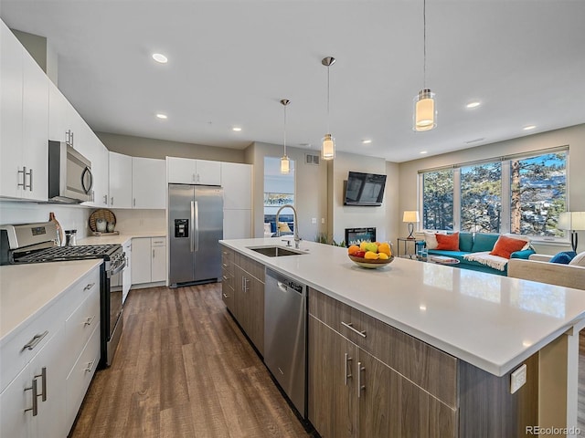 kitchen featuring white cabinetry, pendant lighting, an island with sink, and stainless steel appliances