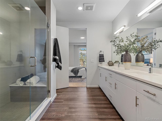 bathroom with vanity, wood-type flooring, and an enclosed shower