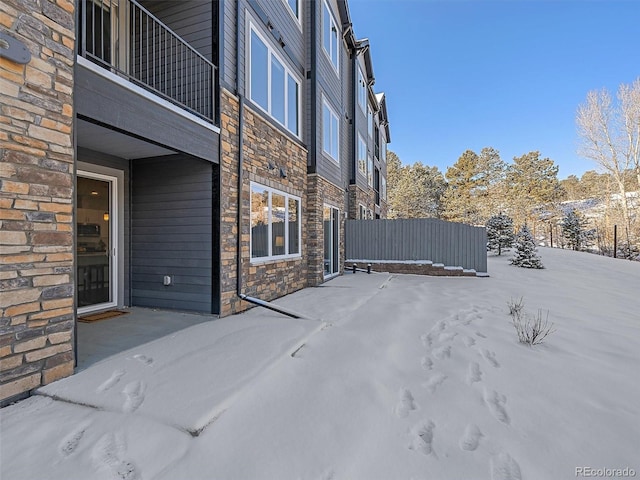 snow covered patio with a balcony