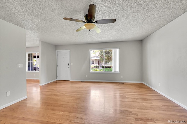 10116 Quivas St, Thornton, CO 80260 - empty room with a ceiling fan, plenty of natural light, light wood-type flooring, and a textured ceiling