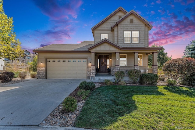 craftsman inspired home featuring a garage, a porch, and a yard