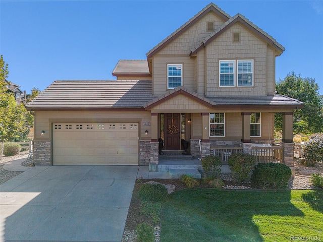 craftsman-style house featuring a garage, a porch, and a front yard