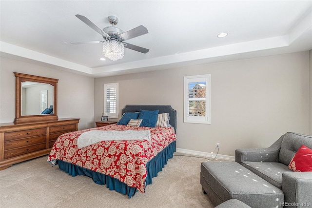 bedroom with ceiling fan, carpet, and a raised ceiling