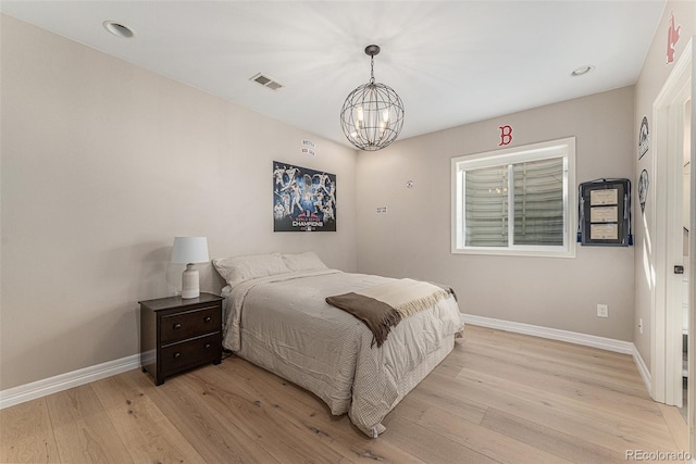 bedroom with a notable chandelier and light hardwood / wood-style flooring