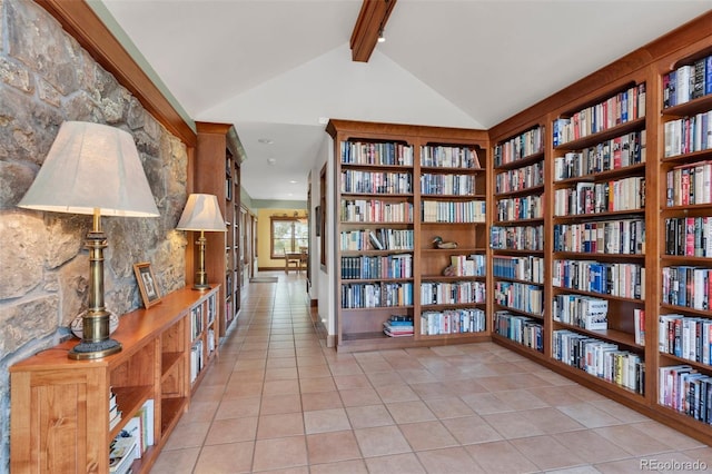 interior space featuring light tile patterned flooring, built in features, and vaulted ceiling with beams