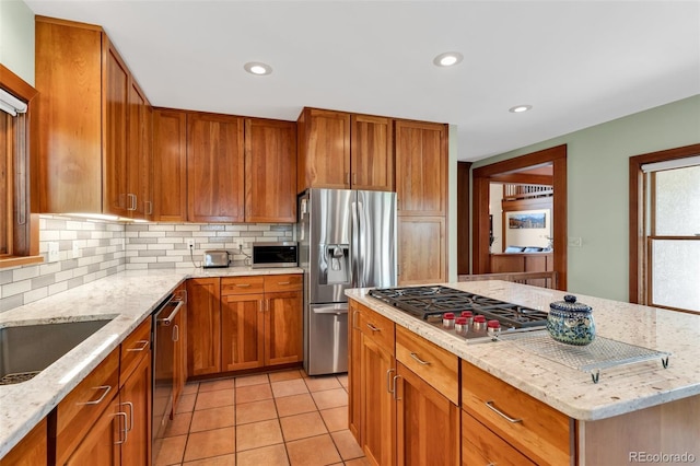 kitchen with light stone counters, light tile patterned floors, decorative backsplash, and appliances with stainless steel finishes