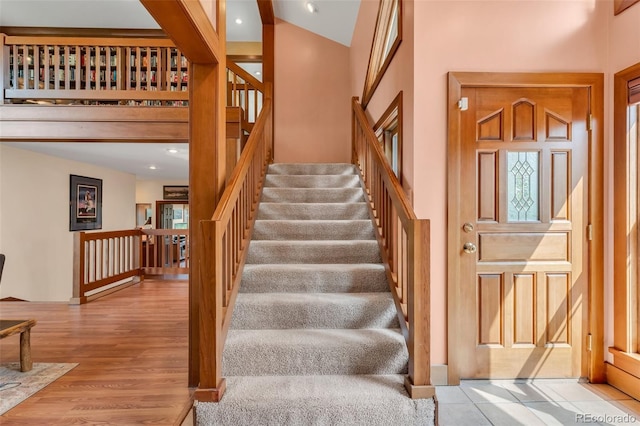 stairway with a high ceiling and hardwood / wood-style floors