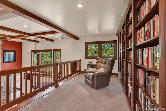 sitting room with beamed ceiling and carpet floors