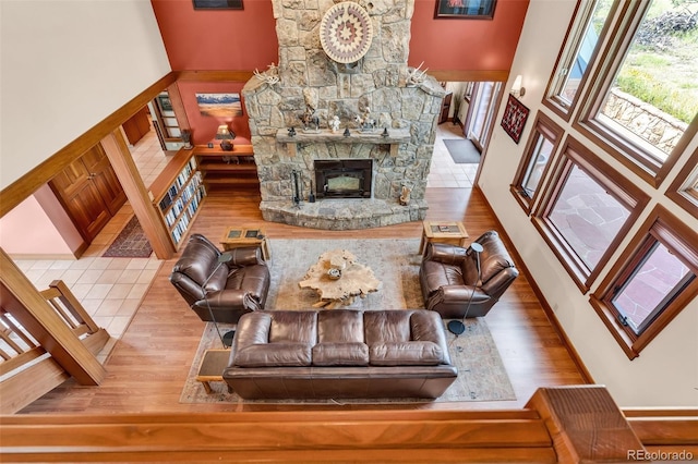 living room featuring a stone fireplace and hardwood / wood-style flooring