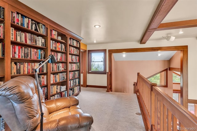 sitting room featuring beam ceiling and carpet floors