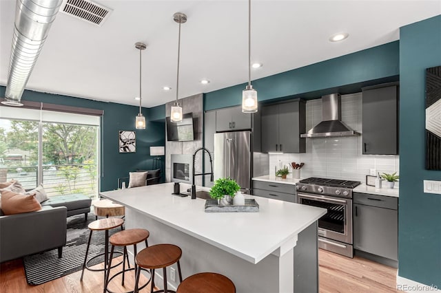 4922 Lowell Blvd Unit 2, Denver, CO 80221 - kitchen with wall chimney range hood, appliances with stainless steel finishes, light wood-type flooring, backsplash, and recessed lighting
