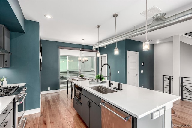 4922 Lowell Blvd Unit 2, Denver, CO 80221 - kitchen featuring a sink, appliances with stainless steel finishes, a center island with sink, light countertops, and light wood-style floors