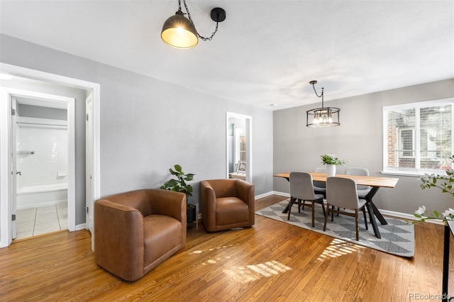 dining area with hardwood / wood-style floors and a chandelier