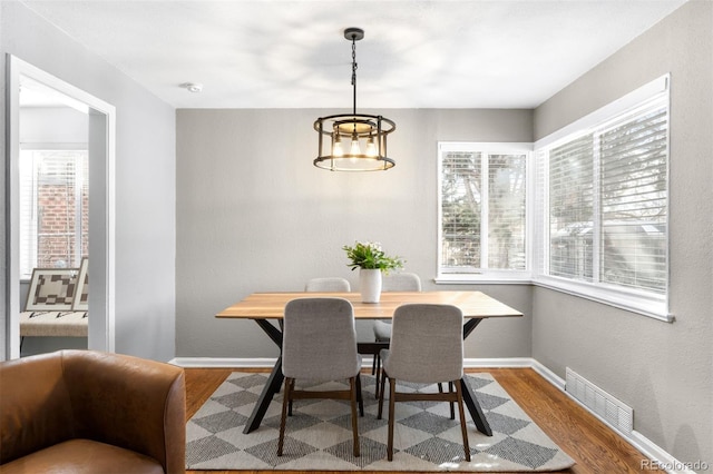 dining room with hardwood / wood-style floors and a notable chandelier