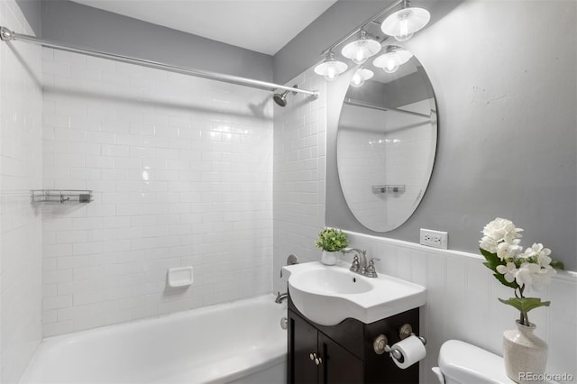 full bathroom featuring vanity, tiled shower / bath, and toilet