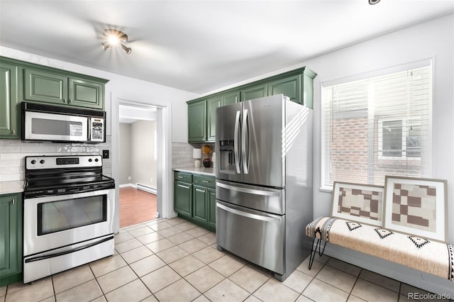 kitchen with appliances with stainless steel finishes, plenty of natural light, green cabinets, and baseboard heating