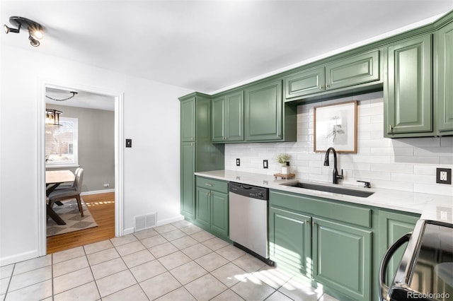 kitchen with sink, green cabinets, stove, light tile patterned flooring, and stainless steel dishwasher