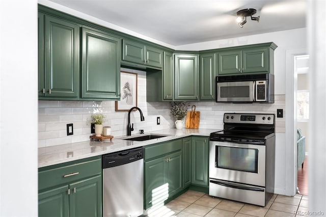 kitchen featuring light tile patterned flooring, green cabinetry, stainless steel appliances, and sink