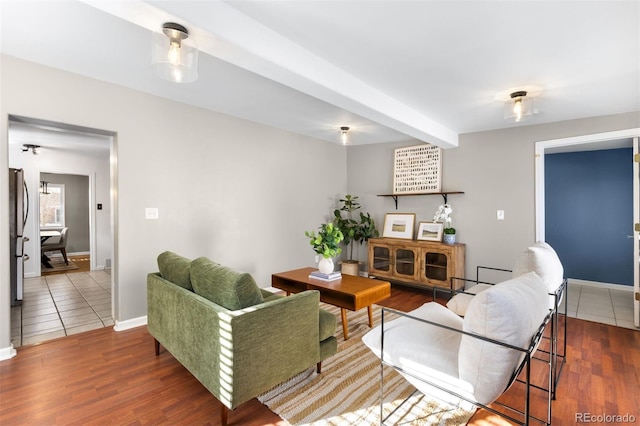 living room featuring beamed ceiling and dark hardwood / wood-style flooring