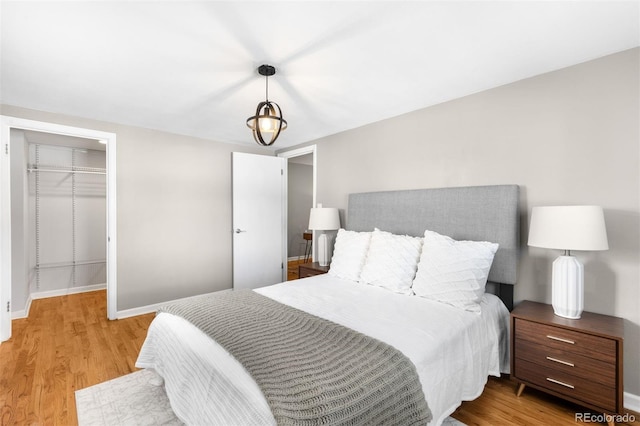 bedroom with a spacious closet, a closet, and light wood-type flooring