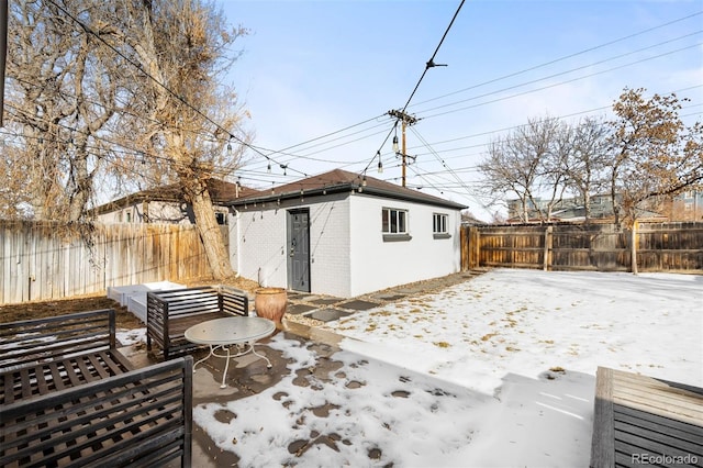 snow covered patio featuring an outbuilding