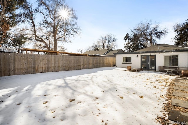 snow covered house featuring a patio