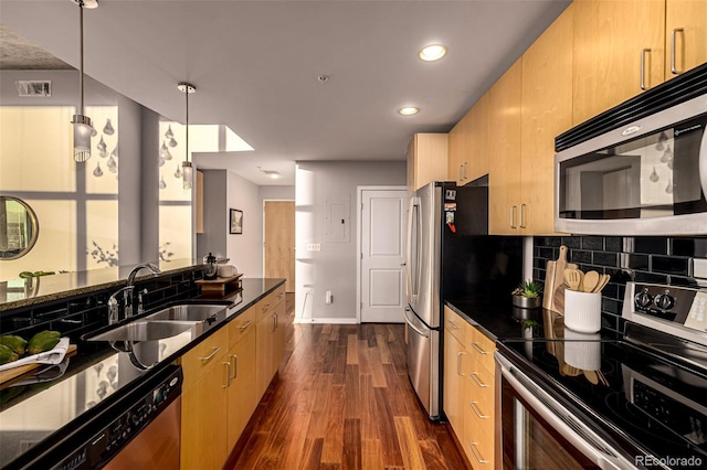 kitchen featuring stainless steel appliances, a sink, visible vents, decorative backsplash, and dark wood finished floors