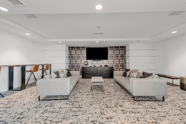 living area with visible vents, a tray ceiling, and recessed lighting